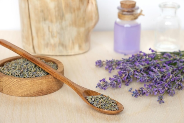 Dry lavender flowers wooden bowl bottle of essential lavender oil infused water Natural cosmetic Spa