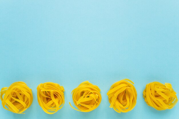 Dry macaroni on a blue background copy space