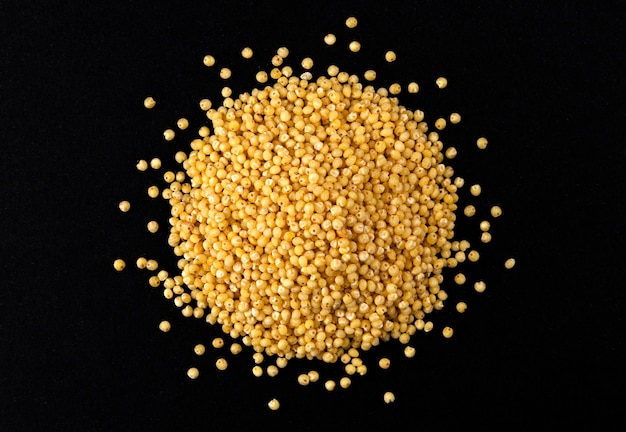 Dry millet groats isolated on black