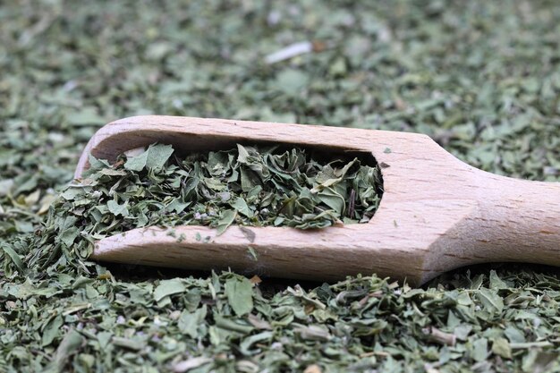 木製の背景に隔離された木製のスプーンで乾燥した薄荷