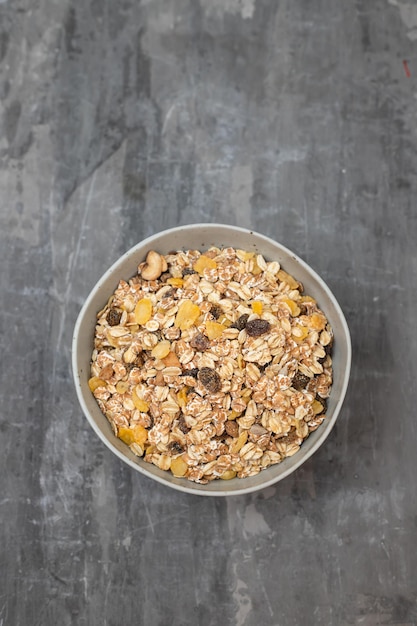 Dry muesli with dry fruits in small bowl