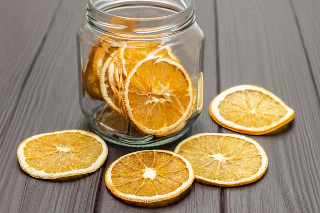 Dry orange slices on the table and in a glass jar