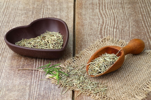 Dry organic background or texture of rosemary leaves Healthy food concept a wooden spoon with rosemary