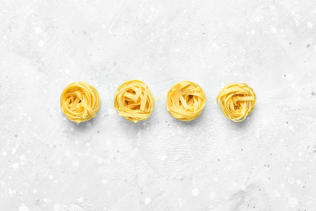 Dry pasta on a gray stone background. Top view. Free space for text.