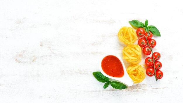 Dry pasta and Ingredients On a white wooden background Top view Free space for your text