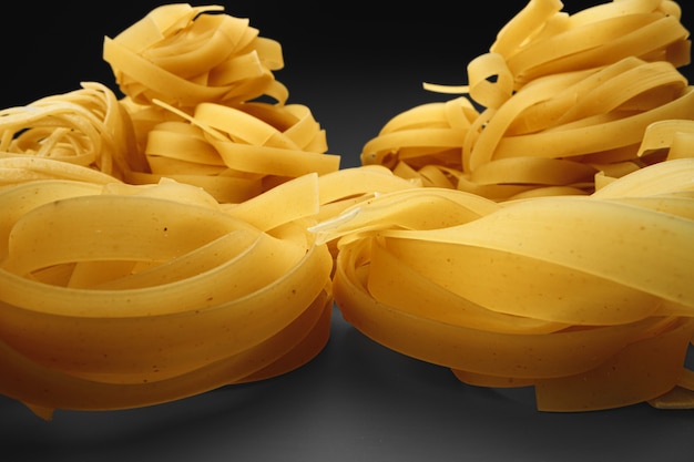 Dry pasta noodles on dark macro photo