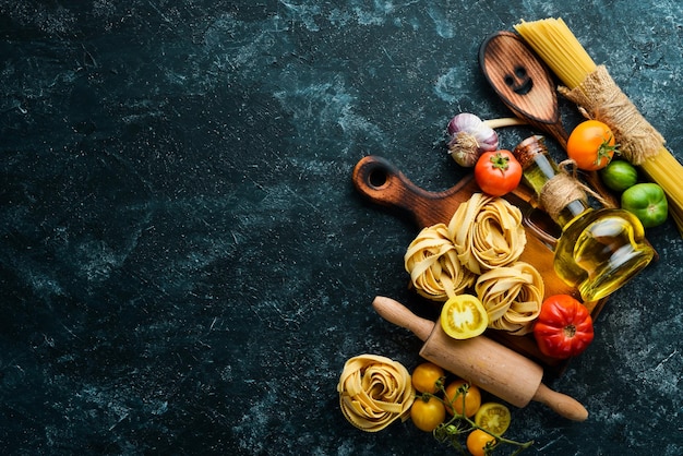 Сухие макароны, помидоры, зелень, масло и ингредиенты, традиционная итальянская кухня, свежие овощи, вид сверху, свободное место для текста