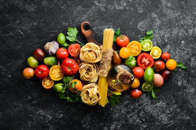 Dry pasta tomatoes greens oil and ingredients Italian traditional cuisine Fresh vegetables Top view Free space for your text