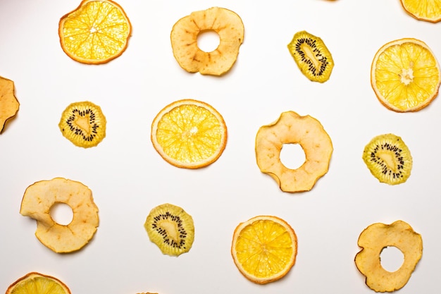 The dry pieces of different fruits in a row to fresh fruits