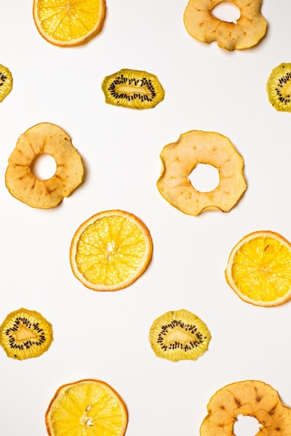 The dry pieces of different fruits in a row to fresh fruits