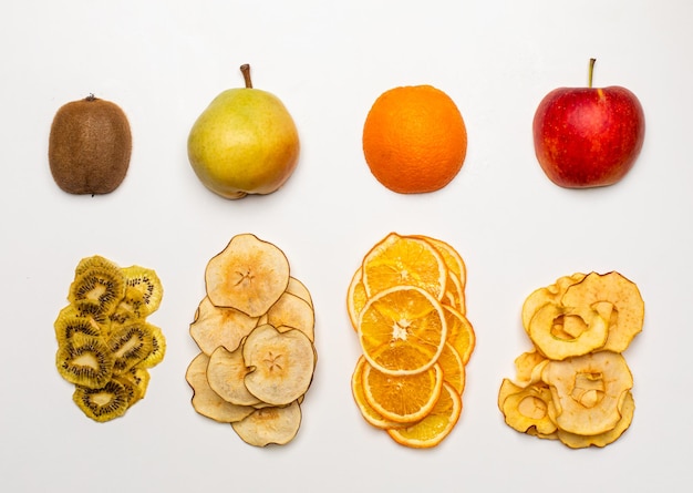 The dry pieces of different fruits in a row to fresh fruits