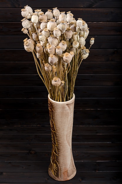 Dry poppy on a dark wooden background. Bouquet.