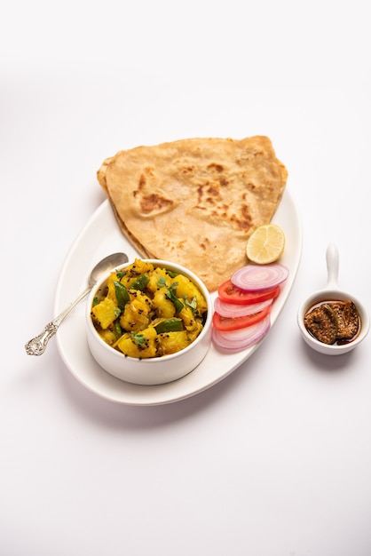 Ricetta di verdure di patate secche con focaccia al triangolo indiano. aloo sabji con tikona paratha o parantha. cibo indiano