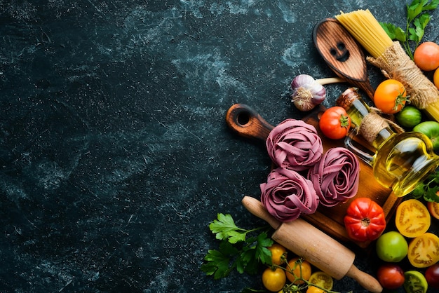 Dry purple pasta with tomatoes and parsley oil Italian traditional cuisine Fresh vegetables Top view Free space for your text