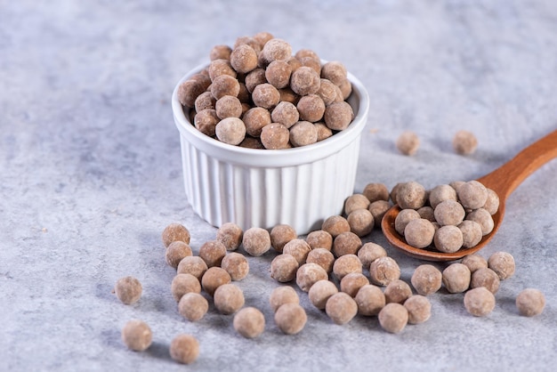 Dry raw brown tapioca pearls isolated on gray cement concrete background close up ingredient of making bubble boba tapioca milk tea