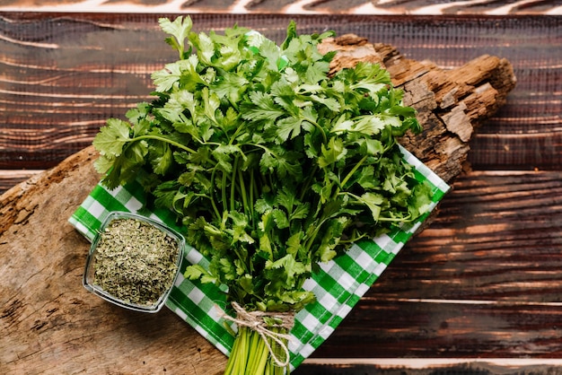 Dry and raw green parsley on wooden background