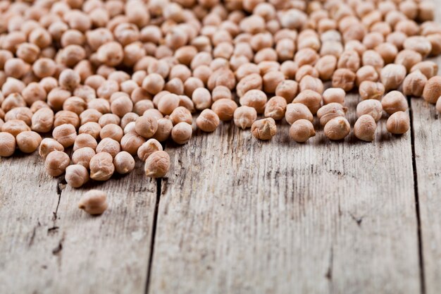 Dry raw organic chickpeas heap on rustic wooden table 