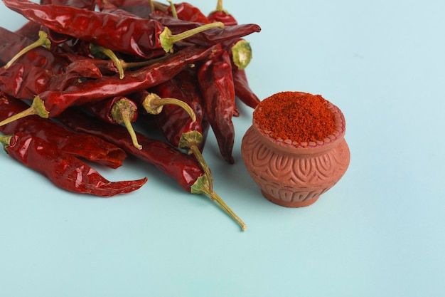 Dry red chilly and powder on white background.