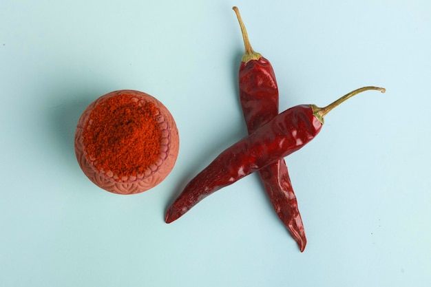 Dry red chilly and powder on white background.