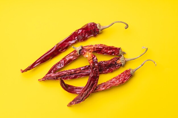 Dry red pepper pods on yellow background