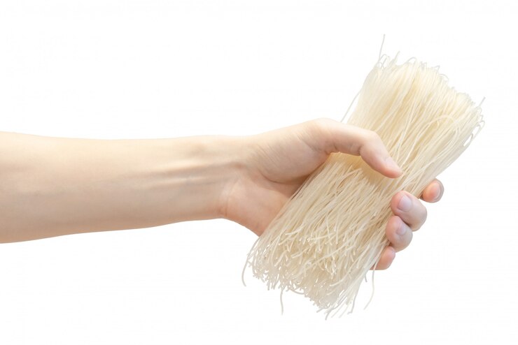 Photo dry rice japanese noodle in men's hand isolated on white