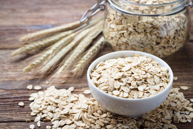 Farina d'avena di fiocchi d'avena rotolata a secco sulla tavola di legno