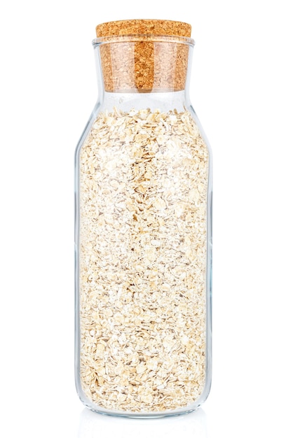 Dry rolled oats in closed transparent glass bottle with cork lid isolated on white