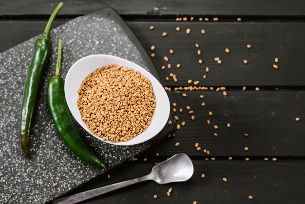 Dry seeds of fenugreek spices on wooden background