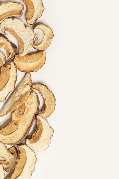 Dry slices of porcini as creative pattern dehydrated food boletus mushrooms top view flat lay beige
