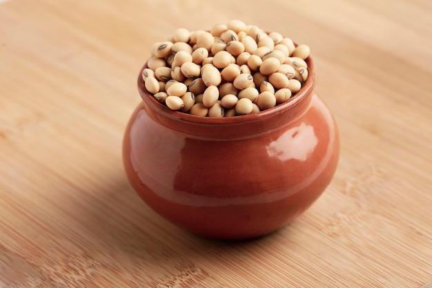 Dry soyabean seed in bowl on wooden background