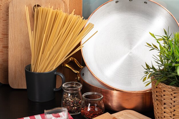 Dry spaghetti on a kitchen counter with cooking utensils close up