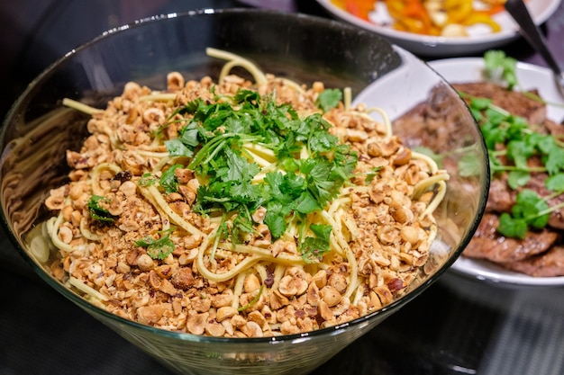 Dry spaghetti noodles with ground nuts and parsley in glass bowl