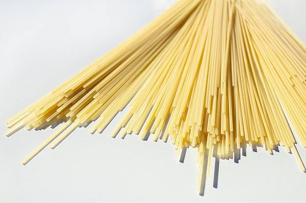 La pasta secca degli spaghetti è sparsa in modo casuale sul tavolo il concetto di cottura della ristorazione