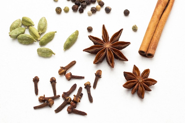 Dry spices cardamom star anise cinnamon sticks and allspice Top view White background