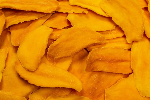 Dry sugar mango slices as a background. top view
