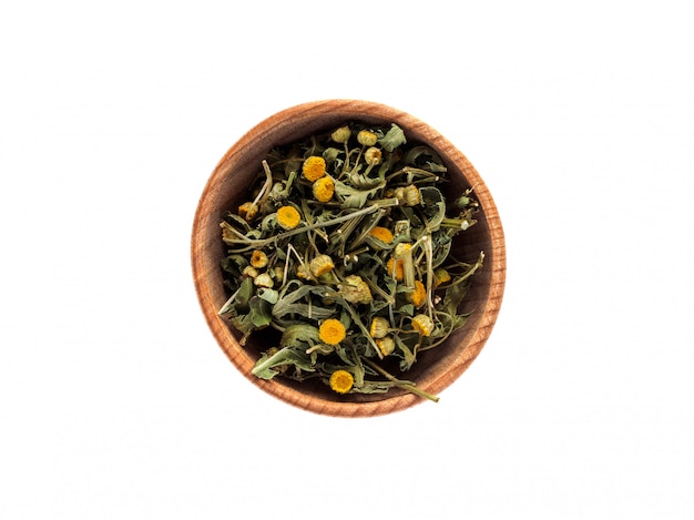 Dry Tanacetum or tansy flowers in a wooden cup on a white table