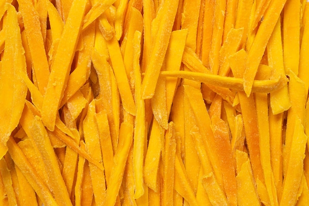 Dry tasty mango slices as a background. Top view.