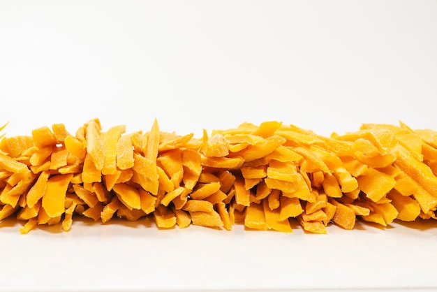 Dry tasty mango slices as a background. Top view.