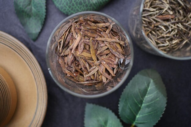 Dry tea leaves in a container on table