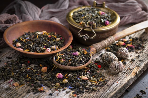 Photo dry tea leaves on a table on an old background