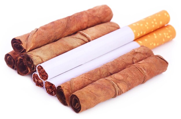 Dry tobacco leaves with cigarette over white background