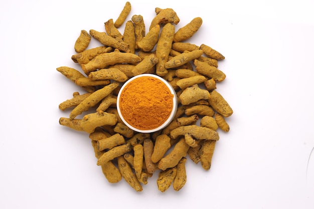 Dry Turmeric  with turmeric powder arranged in a white bowl  with white texture or backgroundtop view