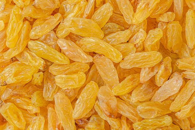 Dry yellow raisins texture, food background