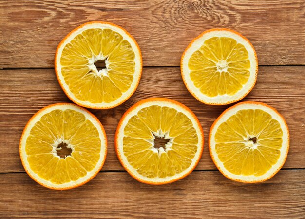 Dryed orange slices on a wooden background. Top view.