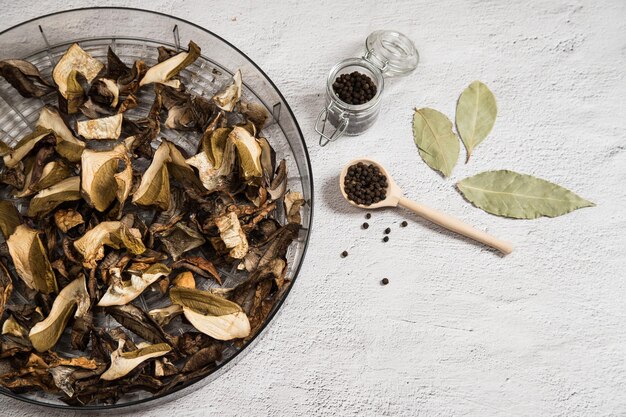 A drying dish filled with dried porcini mushrooms on a gray table