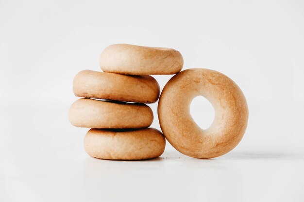 Drying or mini round bagels in the shape of a tower on a white wooden background