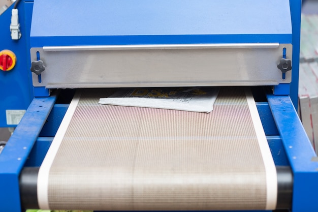 Drying oven for Serigraphy silk screen print process at clothes factory.