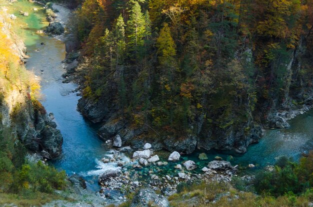 Drying up blue river flows deep in the canyon against the autumn forestNature and wilderness