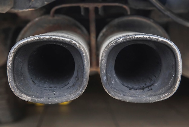 Photo dual car exhaust pipe covered in soot