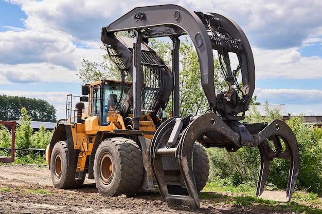 Lo skidder a pinza a doppia funzione si trova a terra all'aperto